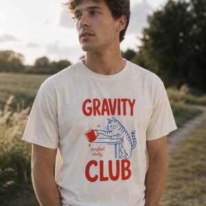 Gravity Club Cat T-Shirt Funny Cat Knocking Coffee Mug Off Table Tee Two Color Cat Lover Graphic Tee Gift imagem 2