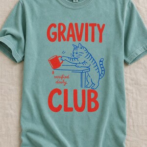 Gravity Club Cat T-Shirt Funny Cat Knocking Coffee Mug Off Table Tee Two Color Cat Lover Graphic Tee Gift imagem 9