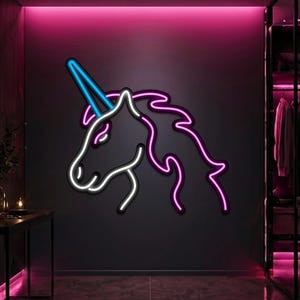 May include: A wall-mounted neon sign depicting the profile of a unicorn head. The design features a bright blue horn, a white outline for the face and neck, and a vibrant pink outline for the flowing mane, all glowing against a dark wall surface.