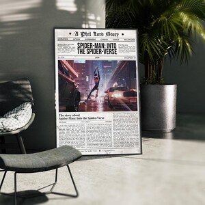 Puede incluir: Un p&oacute;ster enmarcado de la pel&iacute;cula "Spider-Man: Into the Spider-Verse" con dise&ntilde;o de peri&oacute;dico. El p&oacute;ster muestra a Spider-Man en acci&oacute;n con coches de fondo. El p&oacute;ster se exhibe junto a una planta en maceta y una silla.