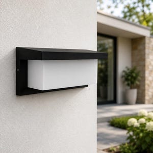 May include: A rectangular outdoor wall light fixture featuring a matte black metal frame with a clean, angular top hood and a frosted white glass diffuser panel that extends horizontally across the center, mounted on a light-colored exterior wall.