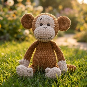 May include: A crocheted monkey toy in shades of brown and cream, with a smiling expression. The soft toy has large ears and is seated on grass. The monkey's arms and legs are extended. The toy is in a natural outdoor setting.