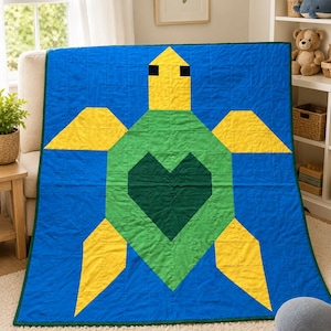 May include: A rectangular quilt featuring a large sea turtle design centred on a blue background. The turtle has a yellow head with black eyes, yellow flippers, and a green body with a dark green heart shape in the centre. The quilt has a dark green border.