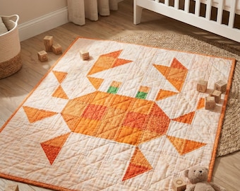 May include: A rectangular quilted blanket featuring a central orange crab design composed of various shades of orange and yellow fabric patches. The quilt has a white background with a subtle grid pattern and an orange border trim.