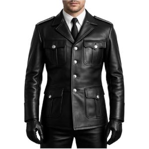 Könnte beinhalten: Schwarze Lederjacke mit vier Fronttaschen, silbernen Knöpfen und Schulterklappen. Die Jacke hat ein klassisches militärisch inspiriertes Design mit einem Reverskragen und einer taillierten Passform. Das Model trägt ein weißes Hemd und eine schwarze Krawatte.