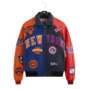 May include: A multi-colored leather varsity jacket featuring a blue and navy front with the text NEW YORK in orange and blue lettering. The jacket is adorned with various embroidered patches including basketballs, KITH logos, and team emblems.