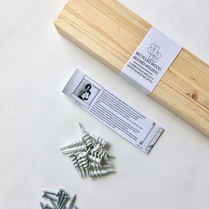 May include: A set of recycled wood record holders with instructions on how to hang them. The set includes screws, anchors, and a wooden frame.