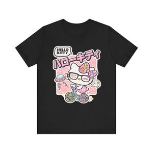 Camiseta con estampado de bicicleta de Hello Kitty | Texto en japonés, estilo kawaii pastel imagen 1