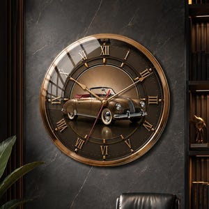 May include: A round wall clock with a metallic gold frame and a dark brown face featuring Roman numerals. The center of the clock displays a detailed illustration of a vintage convertible car in a bronze tone with red accents and thin clock hands.