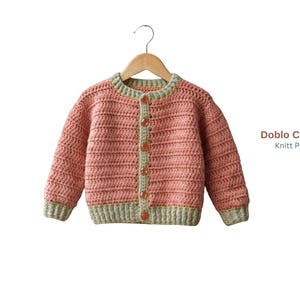 May include: A crochet cardigan in dusty pink with light sage green trim on the collar, cuffs, and hem. The garment features five translucent buttons down the front. Text on the right reads Doblo Cardigan Knitt Pattern with a logo below.