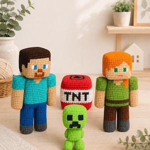 May include: A set of three crocheted dolls and a block. One doll has brown hair and a blue shirt, another has orange hair and a green shirt, and the third is a small green creature. Between them sits a red cube with the white text TNT.