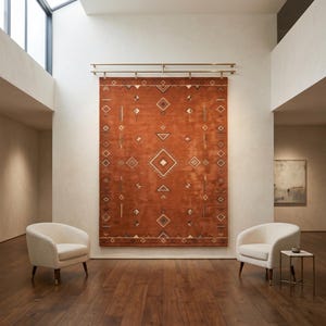 Hand tufted wool rug in rich terracotta featuring a southwestern tribal geometric pattern. Bold diamond medallion centre with concentric borders, ivory and charcoal accents, aztec-inspired motifs. Plush medium pile, artisan crafted, placed on warm oak hardwood floor. Perfect for boho living room, rustic bedroom or as a unique housewarming gift. Custom sizes available.