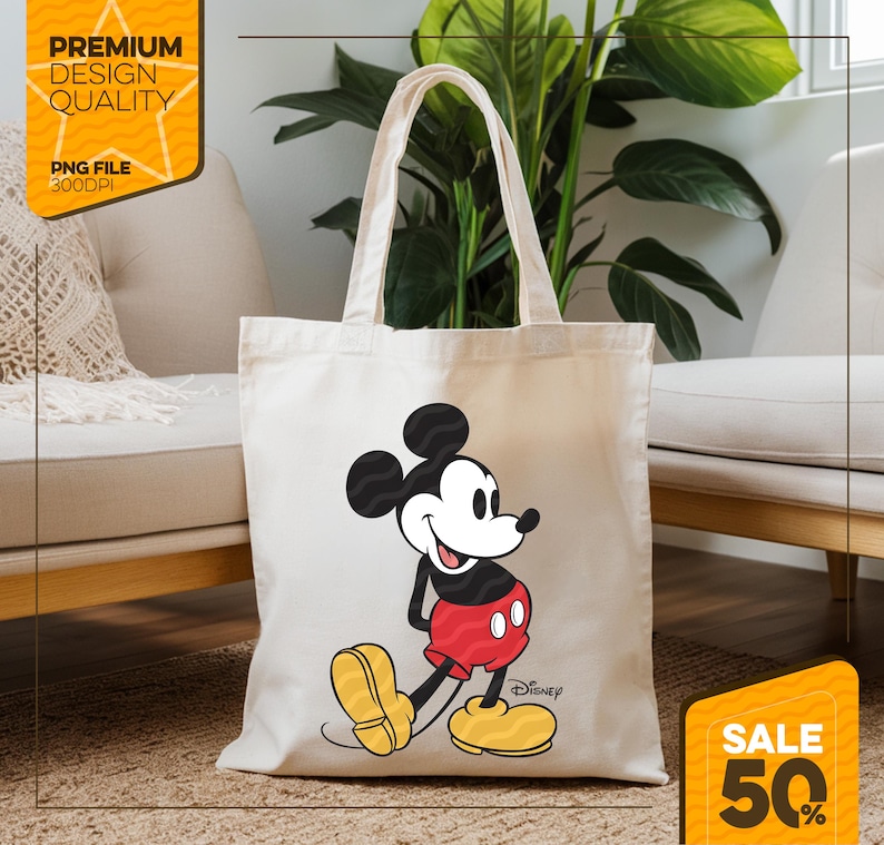 May include: Cream-colored tote bag featuring a smiling Mickey Mouse graphic in red, black, yellow, and white. The bag has long handles and the Disney logo. The image also includes text that says "Premium Design Quality" and "PNG File 300DPI".