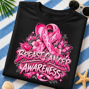 Puede incluir: Una camiseta negra con un diseño gráfico que presenta un gran lazo rosa de concienciación, dos mariposas, flores rosas y corazones. El texto "BREAST CANCER AWARENESS" está impreso en letras rosas llamativas en el centro del diseño.