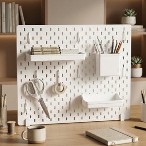 Peut inclure: Un panneau perforé rectangulaire blanc avec des fentes verticales, équipé d'une étagère plate contenant des stylos et une règle, d'un gobelet de rangement pour ustensiles d'écriture, d'un plateau peu profond et de crochets avec ciseaux et ruban.