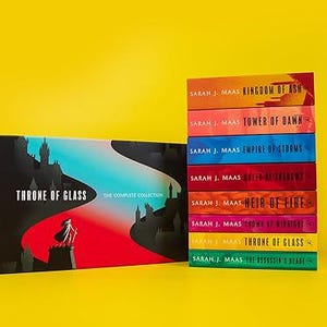 May include: A collection of books from the "Throne of Glass" series by Sarah J. Maas. The set includes a box with the series title and a silhouette design, plus a stack of books with colourful spines.