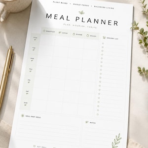 Peut inclure: Un planificateur de repas blanc avec les mots "MEAL PLANNER" en haut. Le planificateur comprend des sections pour chaque jour de la semaine, des idées de préparation des repas, une liste d'épicerie et des notes. Le planificateur a les phrases "Plant Based, Whole Foods, Balanced Living" en haut.