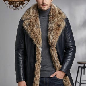 Könnte beinhalten: Ein dunkelblauer Ledermantel mit einem breiten, dicken braunen Kunstfellkragen und Besatz, der sich entlang der Vorderseite erstreckt. Der Mantel wird über einem grauen Rollkragenpullover und einer dunkelblauen Jeans getragen. Ein Logo zeigt SAS LEATHER.