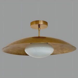 Peut inclure: Un plafonnier en laiton avec un abat-jour large et perforé et un globe en verre blanc arrondi. Le luminaire est monté sur une base et une tige en laiton. Design moderne du milieu du siècle.