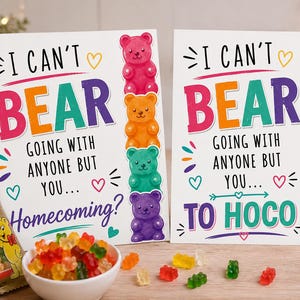 May include: Two white rectangular cards featuring colorful text and a vertical stack of four gummy bear illustrations in pink, orange, green, and purple. The cards read I CAN'T BEAR GOING WITH ANYONE BUT YOU... HOMECOMING? and TO HOCO, with hearts.