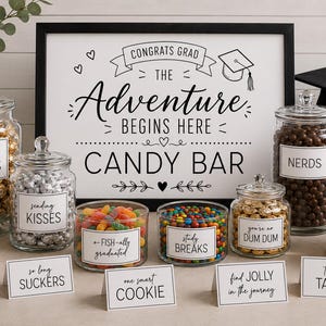 May include: A graduation candy bar display featuring a framed sign that reads CONGRATS GRAD THE ADVENTURE BEGINS HERE CANDY BAR, surrounded by glass jars filled with various candies, each with a label like REACH FOR THE STARS and NERDS.