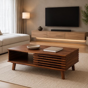 May include: A rectangular dark wood coffee table featuring a slatted side design, four tapered legs, and an open storage shelf. A light-colored ceramic bowl and a closed book are placed on the flat top surface of the wooden furniture piece.