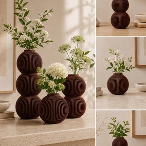 May include: A collection of dark brown, ribbed, spherical vases in various sizes. The tallest vase features three stacked spheres, while others consist of one or two spheres. Each vase holds green stems with white flowers, creating a display.