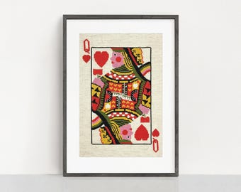 May include: Framed artwork featuring a Queen of Hearts playing card design. The image showcases a colorful, cross-stitched depiction of the queen, with red hearts and a detailed pattern. The artwork is framed in a dark gray frame, suitable for wall decor.