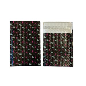 May include: Two rectangular bubble mailers with a black background featuring a repeating pattern of light blue skulls and small pink lightning bolts. One mailer is shown from the front, and the other shows the top adhesive flap section.