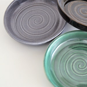 May include: Three ceramic dishes with a spiral design. The dishes are in shades of gray, black, and green.