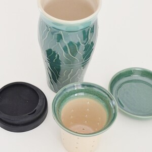 May include: A green ceramic tea infuser with a matching saucer and a black silicone lid. The infuser has a strainer at the bottom and a light brown interior.