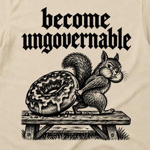 May include: A beige short-sleeve t-shirt featuring a black graphic print of a squirrel standing on a wooden bench and holding a large doughnut. The text "become ungovernable" is printed in a bold, stylised black font above the squirrel illustration.