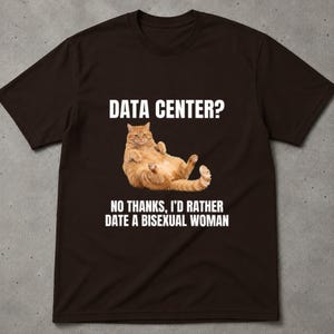 Può includere: Una t-shirt a maniche corte marrone scuro con la grafica di un gatto arancione sdraiato sulla schiena. Sopra il gatto, il testo recita "DATA CENTER?" e sotto il gatto, il testo recita "NO THANKS, I'D RATHER DATE A BISEXUAL WOMAN" in lettere maiuscole bianche.