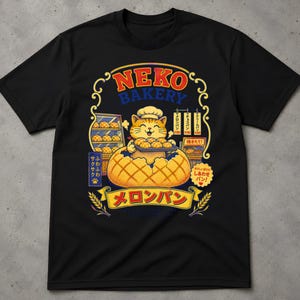 Può includere: Una t-shirt nera a maniche corte con la grafica di un gatto che indossa un cappello da chef e tiene un vassoio di melon pan. Il design include il testo 'NEKO BAKERY' e 'メロンパン', caratteri giapponesi, uno scaffale da panetteria e un'illustrazione di un melon pan.