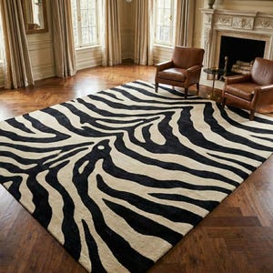 May include: A large rectangular area rug featuring a high-contrast zebra print pattern with bold black stripes set against a creamy off-white background. The rug has a dense, textured pile and covers a significant portion of the wooden floor.