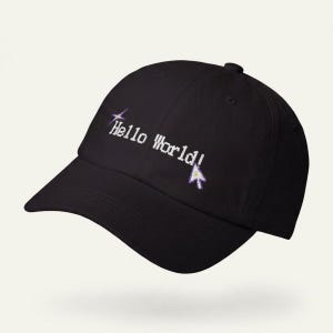 Peut inclure: Casquette de baseball noire avec la phrase "Hello World!" brodée en blanc, accompagnée d'un curseur pixélisé et d'un motif d'éclat d'étoile. La casquette a une visière incurvée et une fermeture à sangle.
