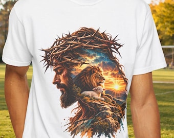 May include: A white short-sleeved t-shirt featuring a graphic print of a profile view of a bearded figure wearing a crown of thorns, with a lion and a lamb integrated into the design against a sunset sky background.