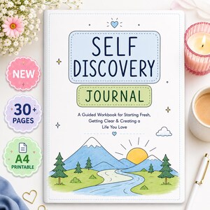 Peut inclure: Un journal de découverte de soi blanc avec un encadré bleu et vert, portant le texte 'SELF DISCOVERY JOURNAL' et 'A Guided Workbook for Starting Fresh, Getting Clear & Creating a Life You Love' au-dessus d'une illustration de montagne et rivière.