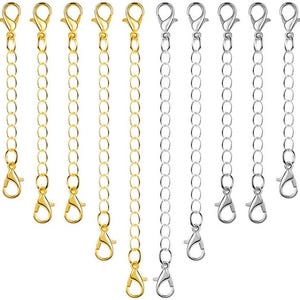 May include: A collection of gold and silver-colored chain extenders with lobster claw clasps. The extenders are arranged vertically, showcasing their length and design. Ideal for jewelry making or adjusting necklace and bracelet sizes.