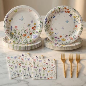 May include: A set of floral-themed disposable paper plates and napkins. The plates and napkins feature a colorful wildflower and butterfly design. Gold-colored forks are also included in the image. The plates are stacked in two piles, and the napkins are in a stack.
