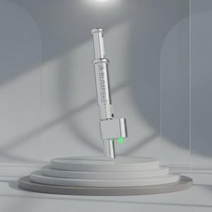 May include: A silver-toned cylindrical metal device with a clear glass section featuring the text BUMPSKE printed in black. The tool has a metallic base with two small, bright green protrusions extending from the bottom, set against a neutral background.