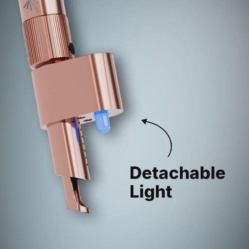 May include: A rose gold colored tool featuring a cylindrical body with a textured grip section and a detachable blue LED light component. The device has a metallic finish and includes a small black button on the side. Text reads Detachable Light.