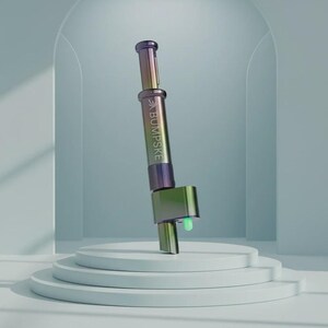 May include: A cylindrical metal tool with an iridescent finish that shifts between purple, green, and gold. The body features the text BUMPSKE printed vertically. It has a plunger mechanism at the top and a small, glowing green light at the base.