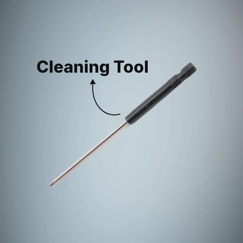 May include: A slender cleaning tool featuring a long, thin metallic rod attached to a black, hexagonal-shaped handle. The text Cleaning Tool is printed above the object with a curved arrow pointing toward the black handle section of the device.