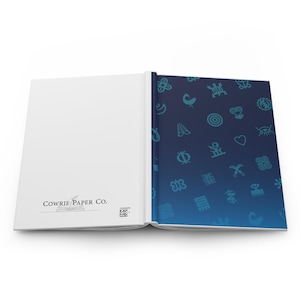 May include: Open journal with a white interior and a blue cover. The cover features teal symbols on a gradient blue background. The left page has the text "COWRIE PAPER CO." and a logo. The journal is open, displaying the inside pages.