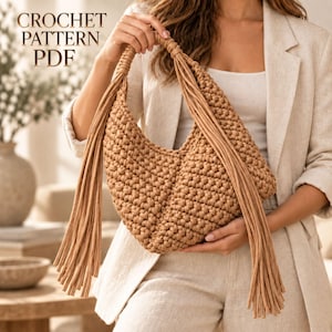 Op de afbeelding: Een beige gehaakte handtas met een gestructureerd knooppatroon en lange, bungelende franjes aan beide kanten van het handvat. De tekst CROCHET PATTERN PDF is zichtbaar in de linkerbovenhoek, wat duidt op een digitaal bestand.