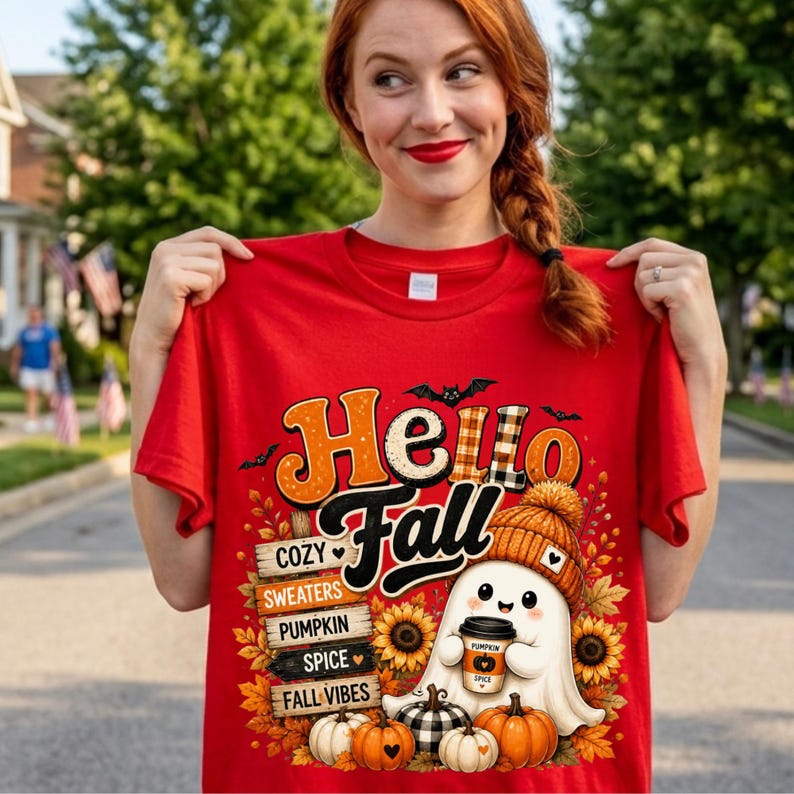 May include: A red t-shirt featuring a graphic print with the text Hello Fall. The design includes a ghost wearing a beanie, holding a coffee cup, surrounded by pumpkins, sunflowers, and a wooden sign listing cozy, sweaters, pumpkin, spice, fall vibes.