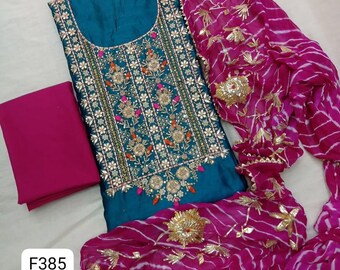 May include: A teal tunic featuring intricate gold embroidery and small pink accents, paired with a solid magenta fabric piece and a magenta scarf with white horizontal stripes and gold floral embellishments. The image includes the text F385.