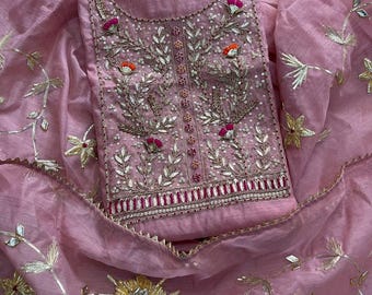 May include: A light pink fabric garment featuring intricate embroidery with silver metallic thread, small clear sequins, and accents of bright pink and orange. The design includes floral motifs and a central vertical panel with detailed stitching.