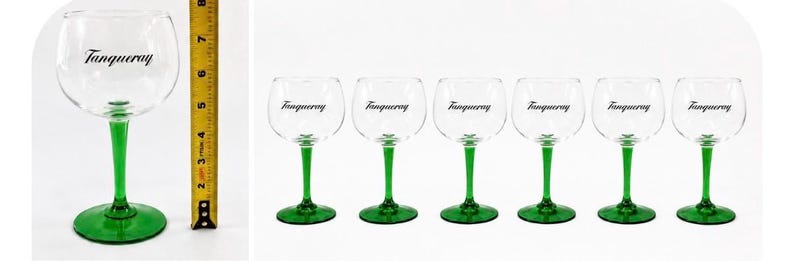 Może przedstawiać: Zestaw sześciu przezroczystych kieliszk&oacute;w do ginu z zielonymi n&oacute;żkami i podstawami. Na każdym kieliszku znajduje się czarny napis "Tanqueray". Kieliszki mają około 18 cm wysokości.